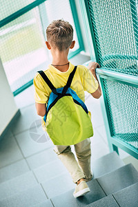 背着书包在学校走廊下楼的男生后视图图片