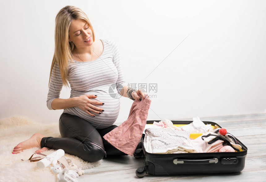 包装婴儿衣服的女人图片