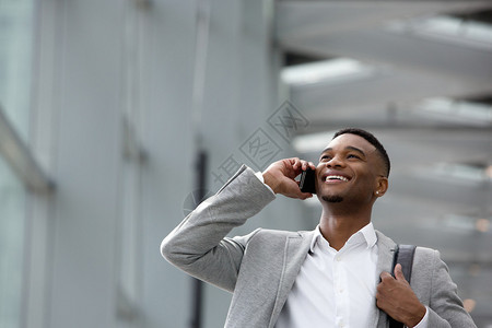 一位快乐的年轻人在大楼内用手机聊天时图片