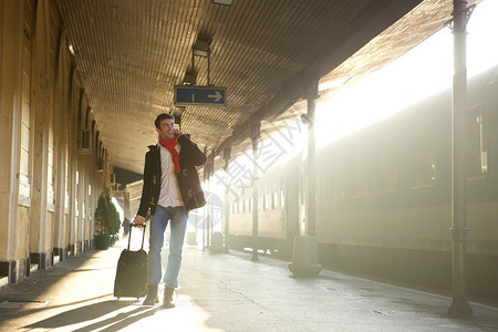 一名青年男子在火车站用手机图片