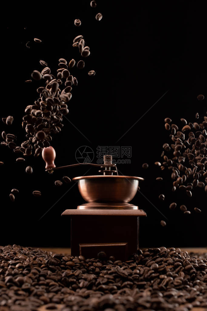咖啡研磨机和新鲜烘烤咖啡豆在黑色图片