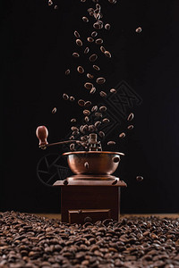 咖啡研磨机和新鲜烘烤咖啡豆在黑色图片