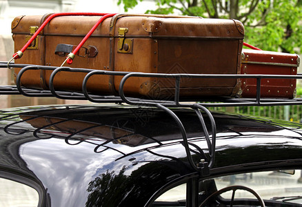 在老式汽车顶上看到的老式手提箱背景图片