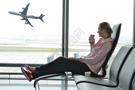 机场窗边喝咖啡的女孩图片
