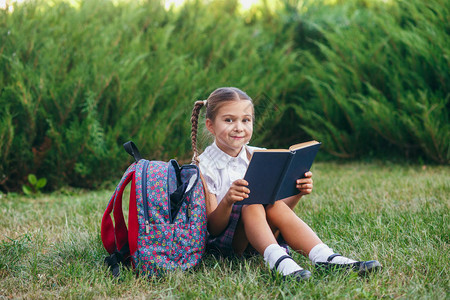 小女孩坐在草地上读书小学生图片