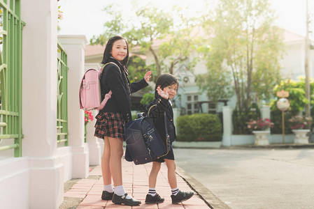 亚洲学生去上学和挥手告别图片