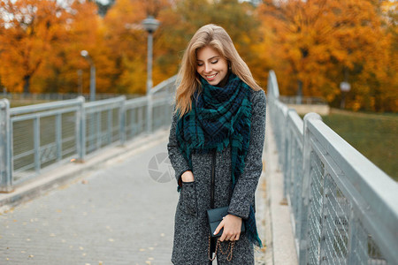 秋天穿着时尚的秋衣穿着围巾在户外行走的图片