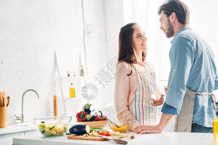 一对夫妇拿着葡萄酒杯在厨房图片