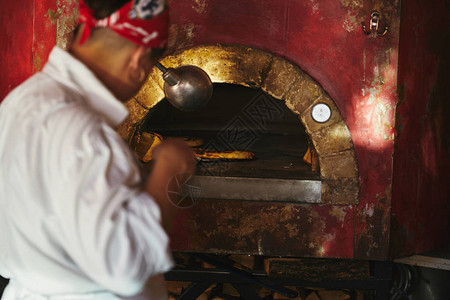厨师在餐厅厨房从烤石炉中图片