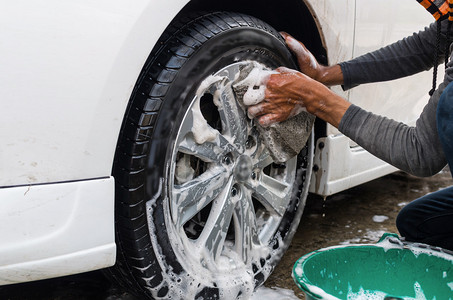 工人在传统洗车店洗车轮图片
