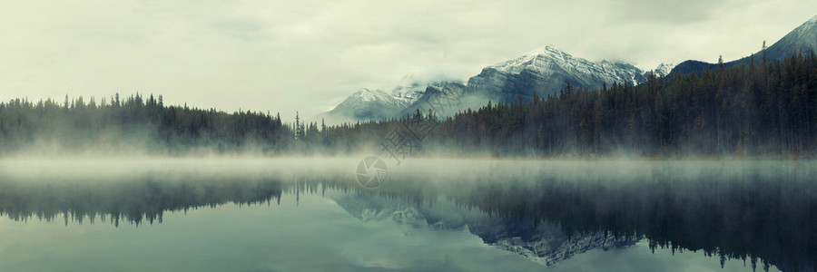 与冰川山和加拿大班夫公园的反射相隔着雾密的清晨图片