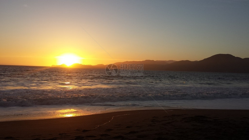 鲜艳的橙色太阳落在海洋上图片