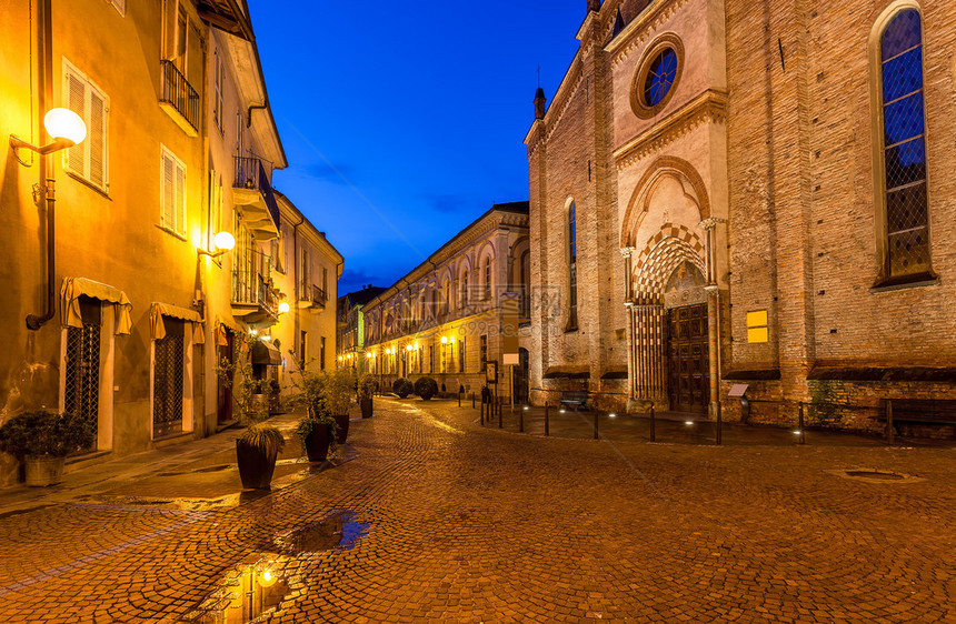 在意大利Alba的旧教堂和带有灯柱的房子之间图片