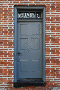 古老的灰色门从一座有砖背景图片