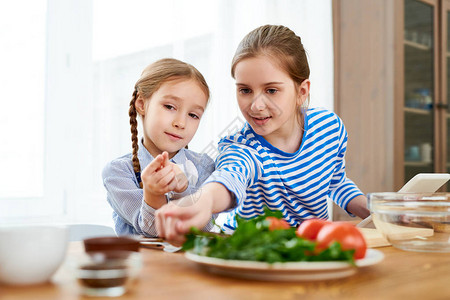在厨房做饭的两个女孩的肖像长姐教小妹图片