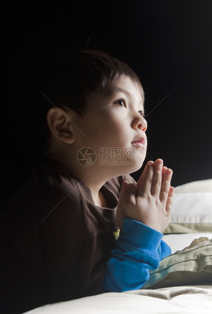 一个小男孩在睡前祈祷图片