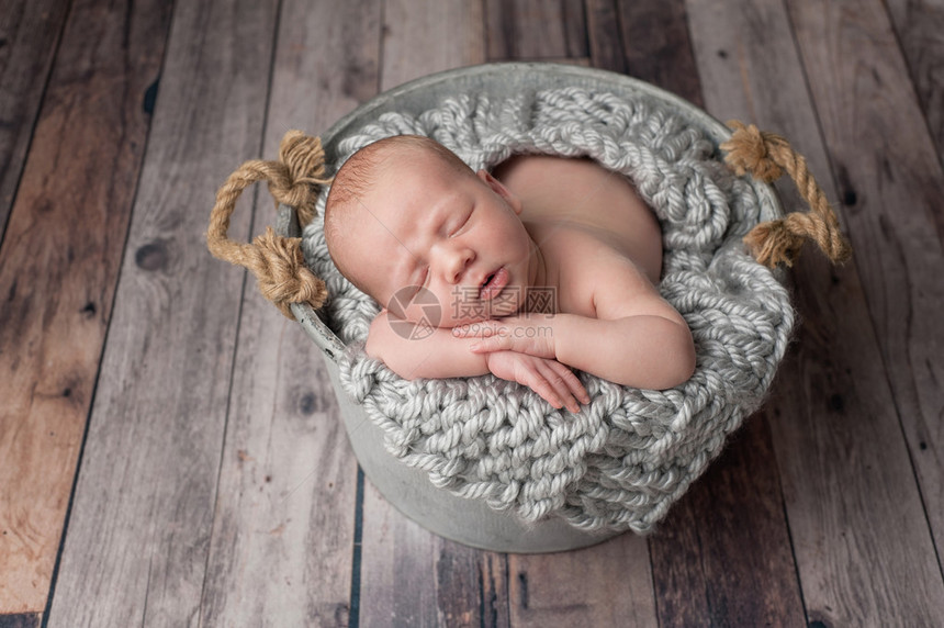 三周前刚出生的男孩睡在灰色镀锌钢桶里图片