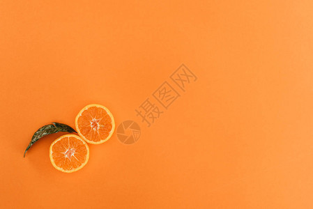 在橙色上隔离的橙色和叶子的顶部视图图片