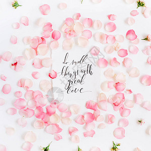 用爱做一些小事引人入胜的引言以书法和花纹形式粉红玫瑰花瓣平坦的躺着背景图片