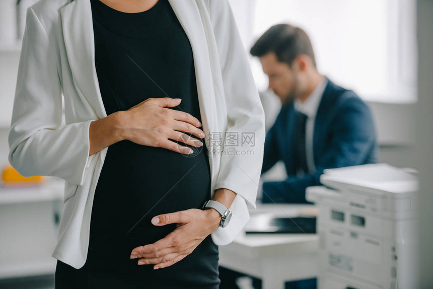 在职工作单位的怀孕女商人和同事的局部视点图片
