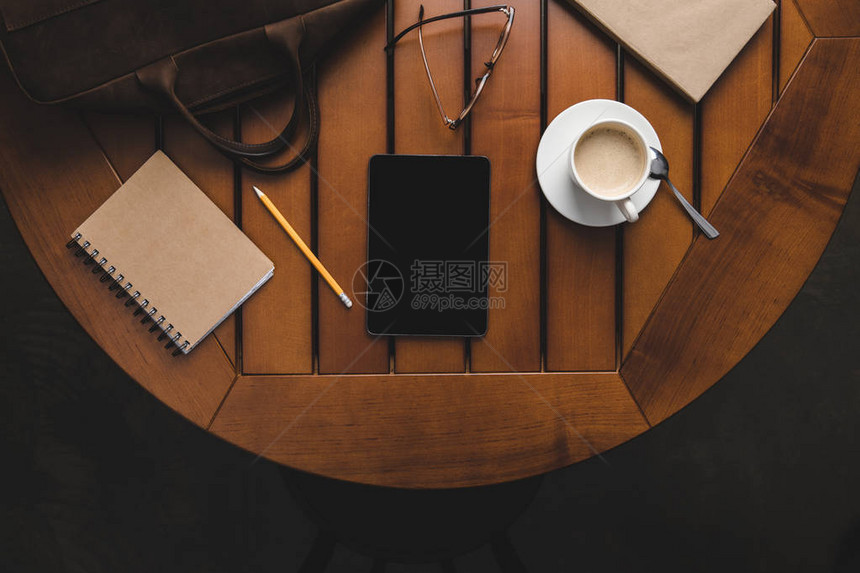 数字平板注纸和木制桌上咖啡图片