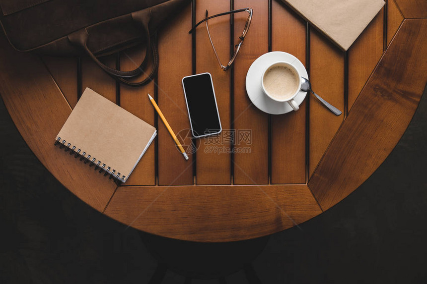 智能手机笔记板和木制桌上咖啡图片