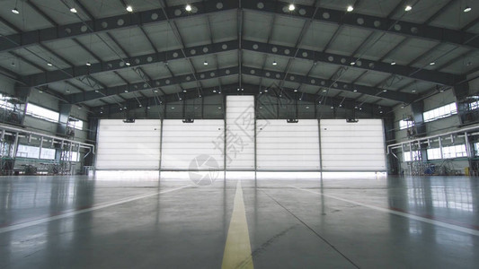 工业背景的厂房内的卷帘门和混凝土地板前面的飞机半开到机库的门机库敞开的门背景图片