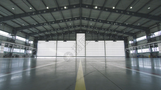 工业背景的厂房内的卷帘门和混凝土地板前面的半开到机库的门机库敞开的门背景图片