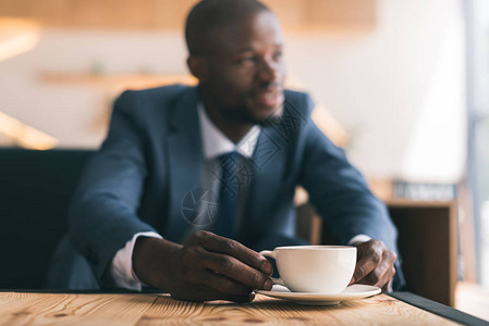英俊的美籍非洲商人在咖啡馆里喝咖啡时有图片