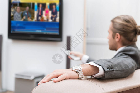 坐在家里看电视的商人图片