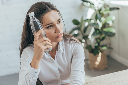 心烦意乱的女商人在热办公室用冷图片