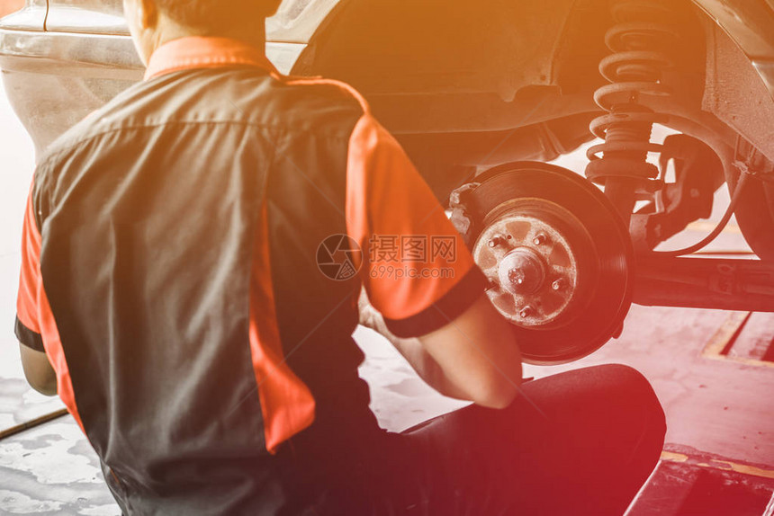 专业汽车修理工在汽车维修服务中更换车轮工人在车图片