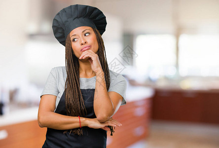 一位年轻的黑人面包师女子思考和抬头图片