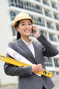 女建筑工地视察员通过电话交谈图片