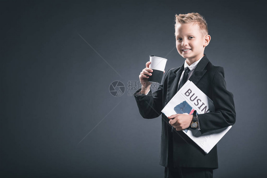 身穿商服的笑男孩肖像喝咖啡和灰色背景图片