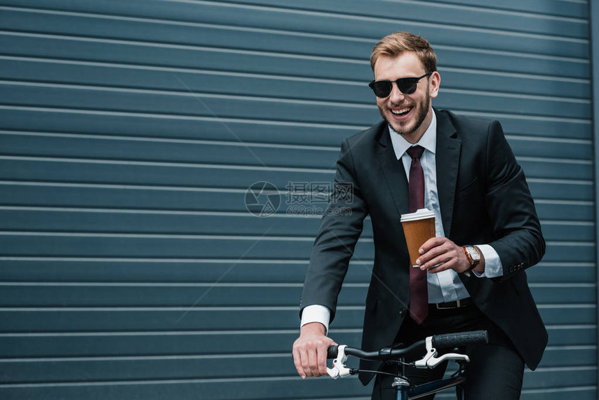 带着纸杯在骑自行车时拿着纸杯的太阳镜上微图片