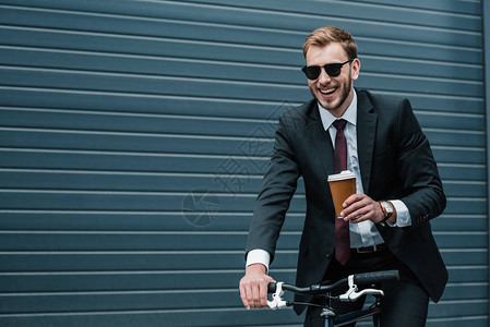 带着纸杯在骑自行车时拿着纸杯的太阳镜上微图片