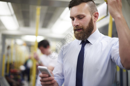 在地铁的年轻商人与电话通图片