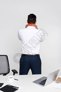 青年商人在工作场所站立时颈部疼痛的反面视图片
