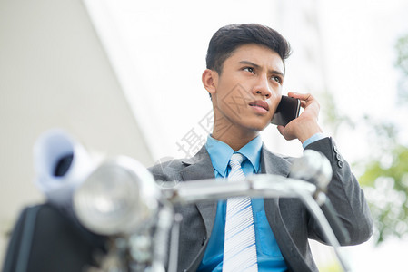 一位严肃的商人在前台用手机聊天的照片图片