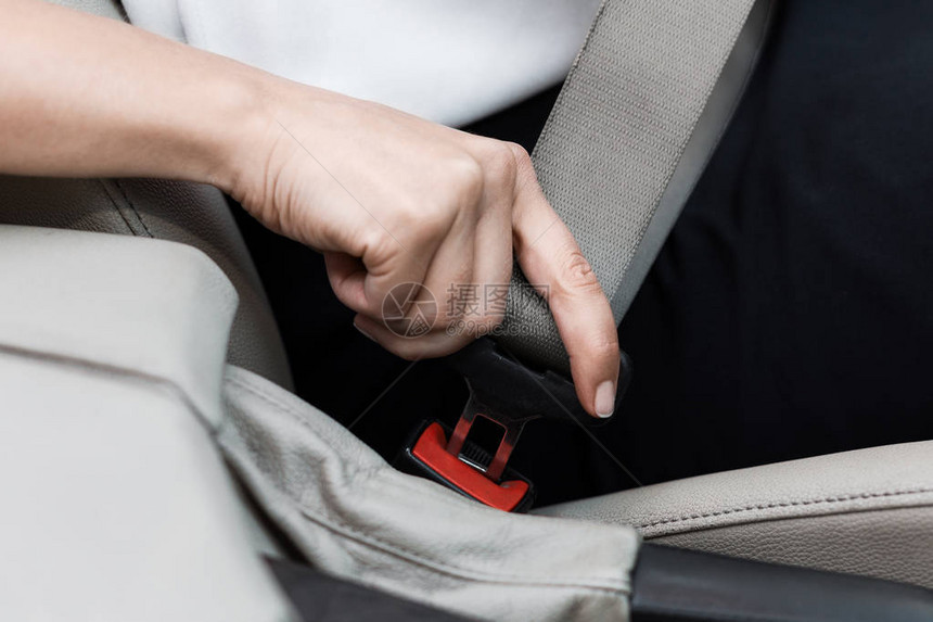 女在驾驶汽车时用手系紧安全带图片