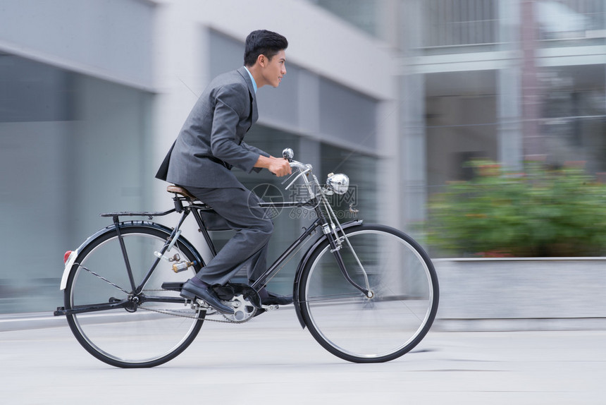 一名活跃商人在上班路上骑自行车驾驶自行图片