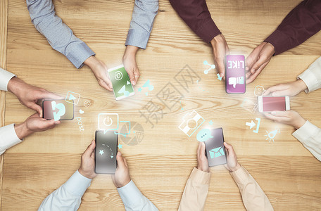利用社交媒体在木制桌面上的智能手机举行会议的商界图片