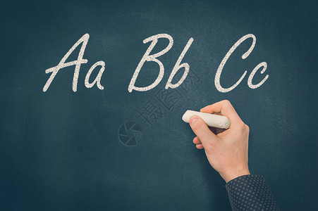 用粉笔在黑板上写ABC字母的人图片