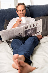 中年男子阅读报纸和躺在图片