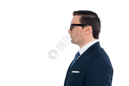 穿着西装和眼镜的商人的侧视图站在白色上孤图片