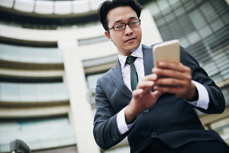 亚洲商业家智能手机短信讯息的低图片