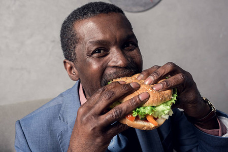 正在吃汉堡的非洲男人背景图片