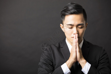 有祈祷手势的年轻商人图片