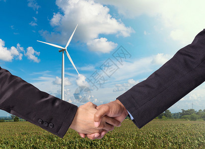 在风力涡轮机发电机背景上一个商人图片